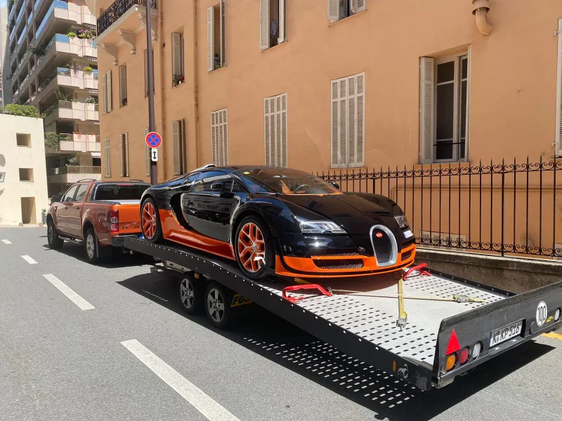 Schwarz-oranger Bugatti Veyron auf dem Transportanhänger von K.P.-Transporter